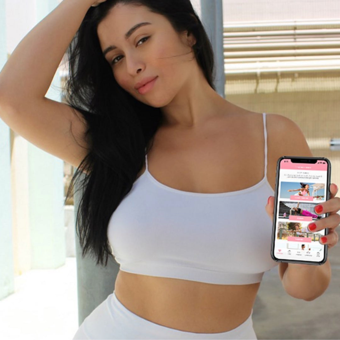 Woman showcasing flat tummy app on phone