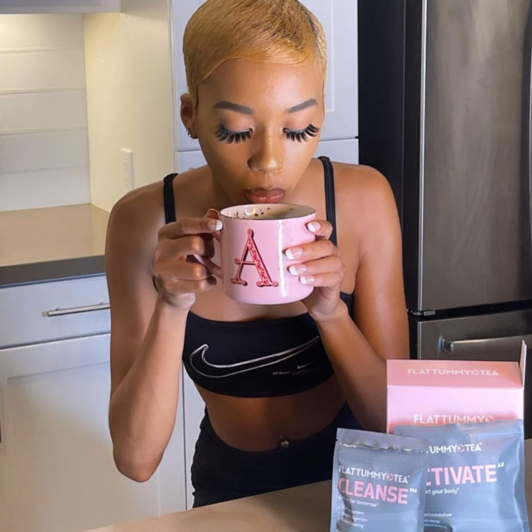 woman blowing on cup of flat tummy tea