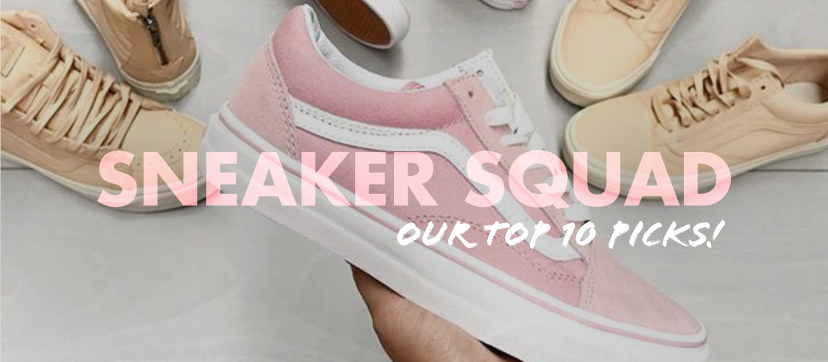 A hand holds a pink and white sneaker in the foreground. In the background, various beige and tan sneakers are scattered. Bold text reads "Sneaker Squad" with "Our Top 10 Picks!" written beneath it.