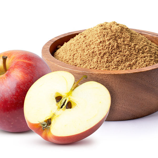 A wooden bowl filled with apple cider vinegar powder is placed next to a whole apple and a halved apple.