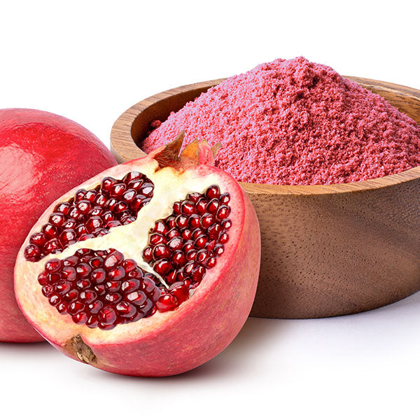 A wooden bowl filled with red pomegranate powder.